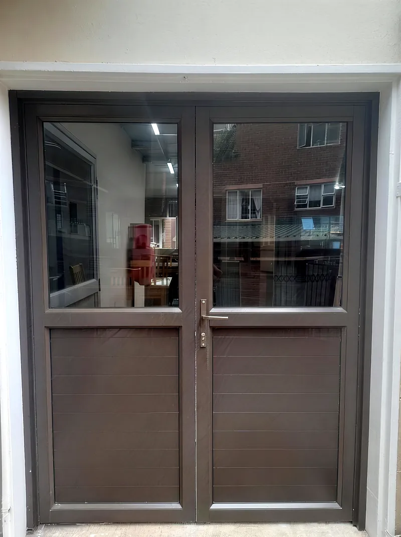 After: new bronze aluminium double entrance doors with glass and solid panels