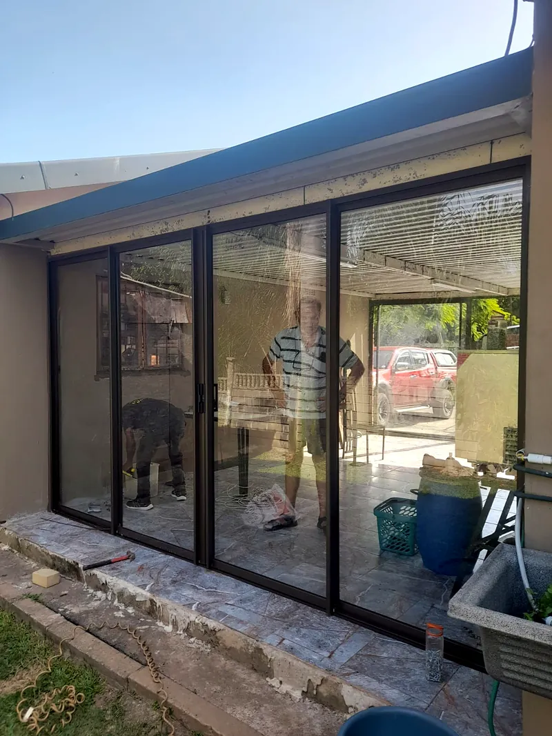 Patio enclosure frames being fitted on site