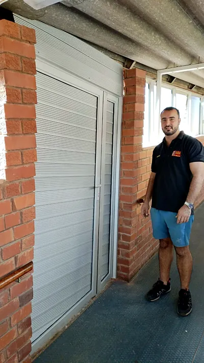 Newly fitted single aluminium louvre door in a brick passage