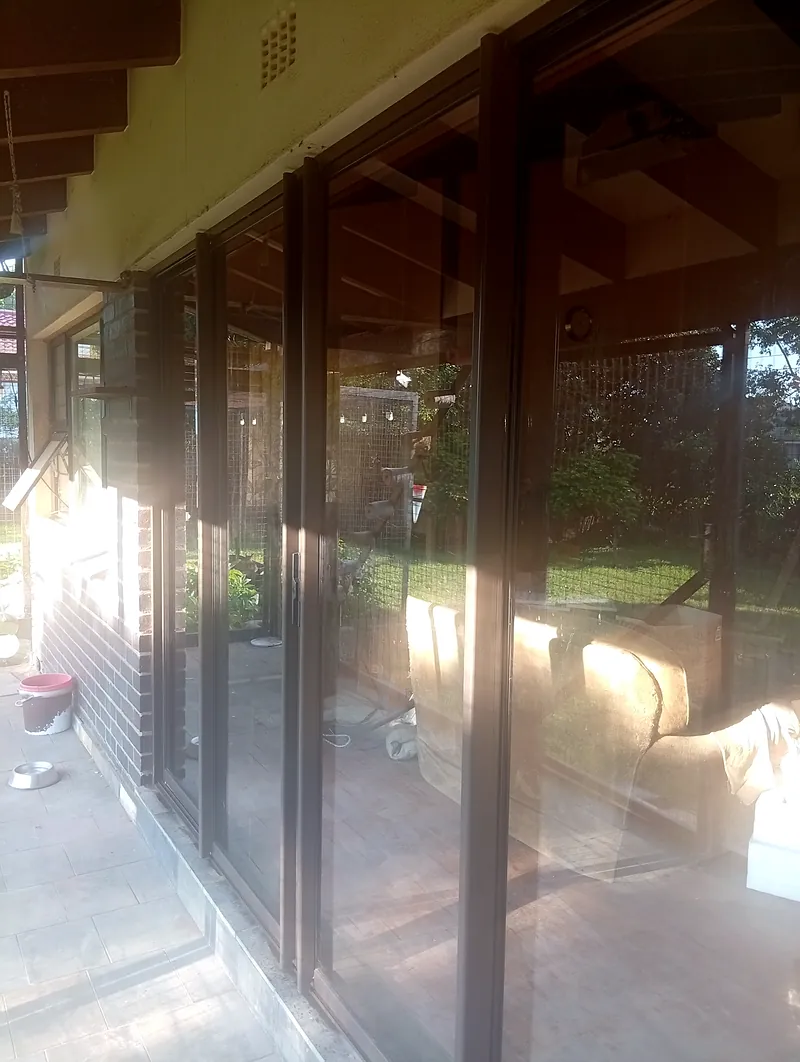Run of bronze aluminium sliding doors, late afternoon light